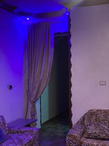a purple room with a bed and a curtain at Cozy Apartment in Asyut شقة لك بالكامل in Asyut