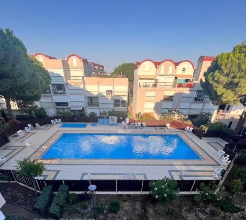 une grande piscine devant un immeuble dans l'établissement L'appart D79, à Gruissan