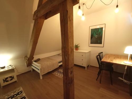 a room with a bed and a table and a desk at Lemuria Pokoje Hostel Chojnowska A in Legnica