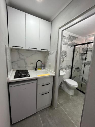 a small kitchen with a sink and a toilet at YALı APART HOTEL in Trabzon