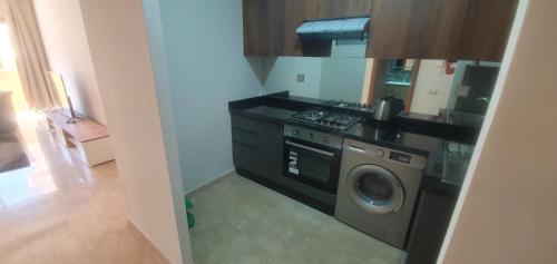a kitchen with a washing machine and a stove at Taj linving in Nouaceur