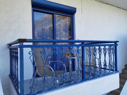 a blue railing on a balcony with a window at Marinas Studios in Livadia
