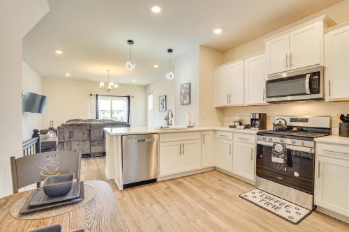 a kitchen with white cabinets and a stove top oven at Frederick Townhome with Balcony, Close to Parks! in Frederick
