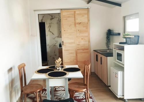 a kitchen with a table with chairs and a white refrigerator at Kataenea. Apartamento en el prepirineo navarro. Naturaleza in Aoiz