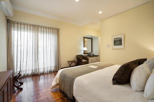 a bedroom with a bed and a desk and a window at Terrazas de los Andes Guest House in Ciudad Lujan de Cuyo