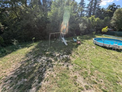 - une vue aérienne sur une cour avec une aire de jeux et une piscine dans l'établissement Maison 3 chambres, extérieur avec piscine, à Aubres