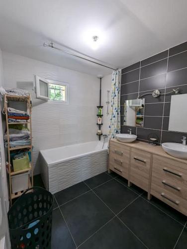 une salle de bain avec une baignoire et un lavabo et une baignoire dans l'établissement Maison 3 chambres, extérieur avec piscine, à Aubres