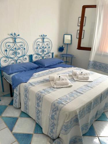 a blue and white bed with two towels on it at Punta Est bellissimo 3 camere vista mare in Capo Coda Cavallo