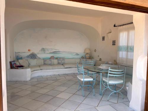 a living room with a couch and a table and chairs at Punta Est bellissimo 3 camere vista mare in Capo Coda Cavallo