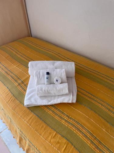a bed with two towels and a bottle of soap at Punta Est bellissimo 3 camere vista mare in Capo Coda Cavallo