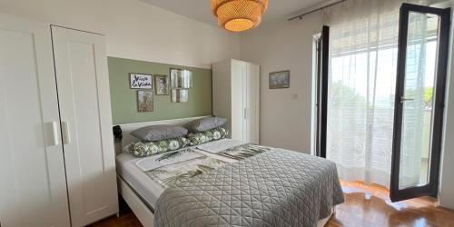 a bedroom with a bed and a large window at Apartments Stella in Piran