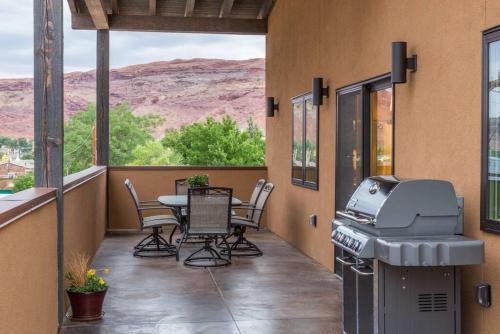 a patio with a table and chairs and a grill at 57 Robber's Roost in Moab