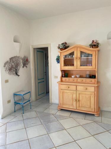 a room with a wooden cabinet and a blue chair at Punta Est bellissimo 3 camere vista mare in Capo Coda Cavallo