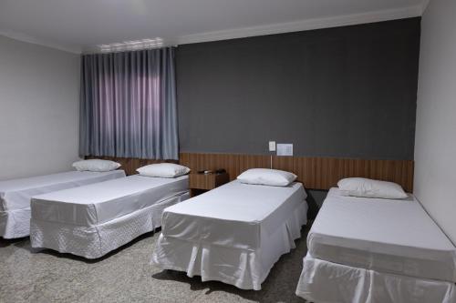 a hospital room with three beds in it at BOMBONATO HOTEL - Fácil Acesso ao Aeroporto e parque de Exposições ABCZ in Uberaba