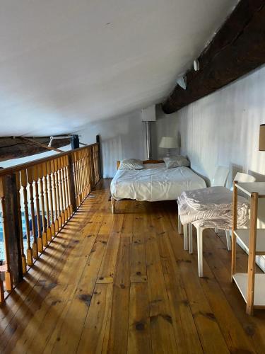 une chambre avec deux lits et un parquet dans l'établissement Maison chaleureuse à Ille-sur-Têt, jardin paisible, clim & cheminée, à Ille-sur-Têt