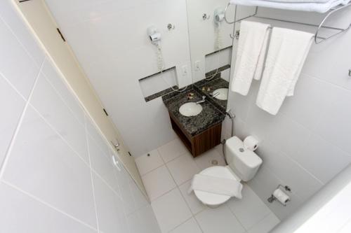a white bathroom with a toilet and a sink at Lacqua diRoma Oficial - diRoma Acqua Park Incluído - in Caldas Novas
