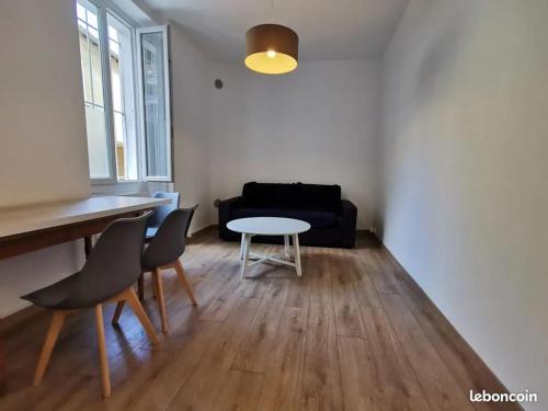 un salon avec une table, des chaises et un canapé dans l'établissement Appartement charmant à Avignon, 40 m², proche du centre historique, à Avignon
