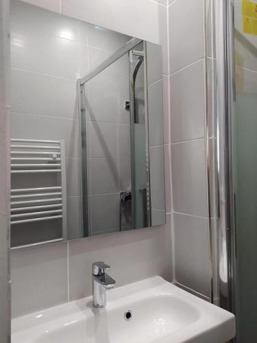 une salle de bain blanche avec un lavabo et un miroir dans l'établissement Appartement charmant à Avignon, 40 m², proche du centre historique, à Avignon
