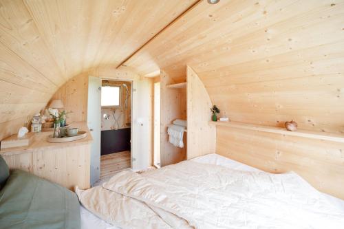a small bedroom with a bed in a wooden room at Notte nella Botte in Vignale Monferrato