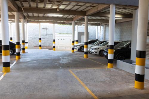 a parking lot with yellow and black poles and cars at BOMBONATO HOTEL - Fácil Acesso ao Aeroporto e parque de Exposições ABCZ in Uberaba