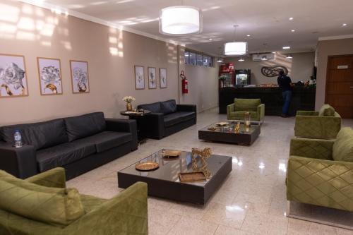 a living room with couches and chairs and a table at BOMBONATO HOTEL - Fácil Acesso ao Aeroporto e parque de Exposições ABCZ in Uberaba