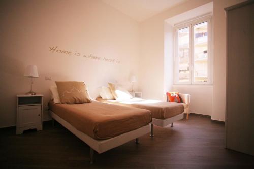 un dormitorio con dos camas y un letrero que dice que el hogar es donde en Red Flat In Rome en Roma