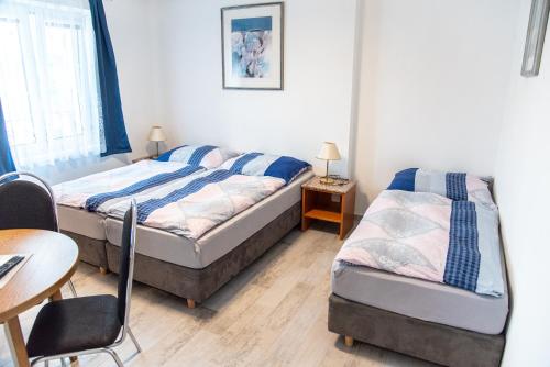 a bedroom with two beds and a desk and a table at Panská in Chlum u Třeboně