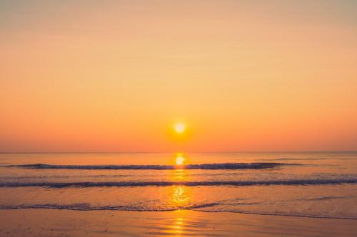 a sunset on the beach with the sun setting at Sunset Villa - Beachfront Villa with Private Pool by Karula in Cabo Nhamua