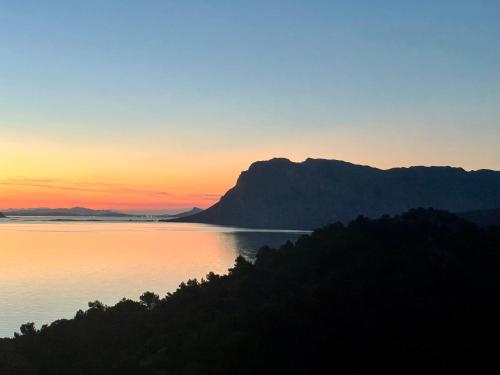 a sunset over a body of water with a mountain at Punta Est bellissimo 3 camere vista mare in Capo Coda Cavallo
