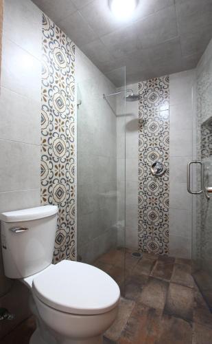 a bathroom with a toilet and a glass shower at Hotel Boutique Casa Téllez in Maboro