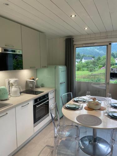 une cuisine avec une table et des chaises et une cuisine avec une fenêtre dans l'établissement La Baie des Voiles 3 chambres 4 à 6 personnes au bord du lac plage privée, à Duingt