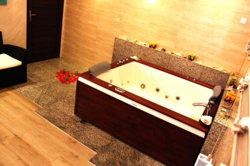 a bath tub in a bathroom with a sink at Hotel Monet & Rubbens in Toruń