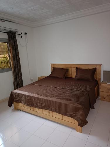 a bedroom with a wooden bed in a room at Berlin in Ziguinchor