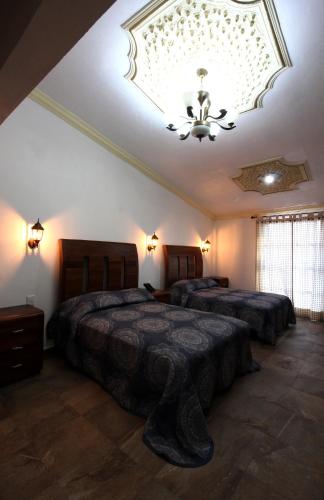 a bedroom with two beds and a ceiling at Hotel Boutique Casa Téllez in Maboro