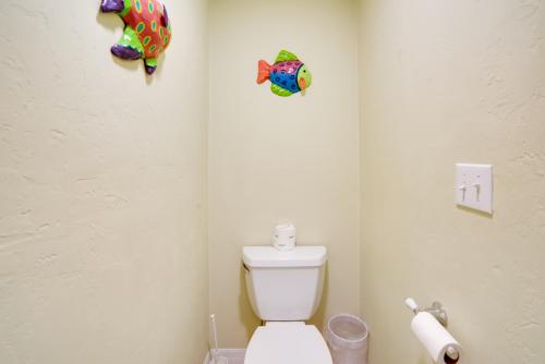 a bathroom with a toilet and two fish on the wall at Oceanfront Oasis in Cedar Key with 2 Balconies! in Cedar Key