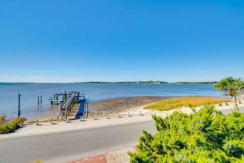 a dock on a beach next to the water at Oceanfront Oasis in Cedar Key with 2 Balconies! in Cedar Key
