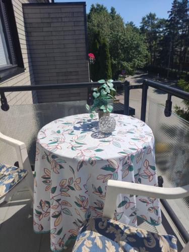 a table and chairs on a balcony with a vase on it at Oasis Apartments in Pärnu