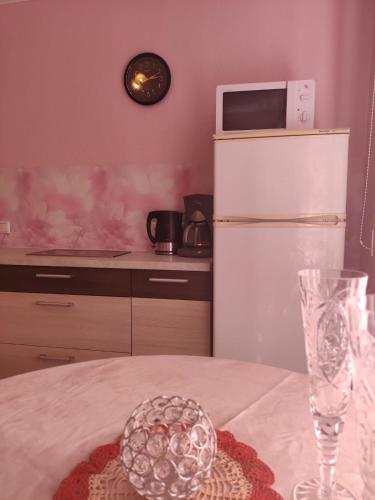 a kitchen with a table with a white refrigerator at Oasis Apartments in Pärnu