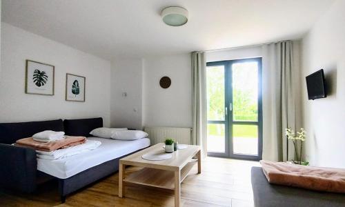 a bedroom with a bed and a couch and a table at Domki na Wodnej in Kołobrzeg