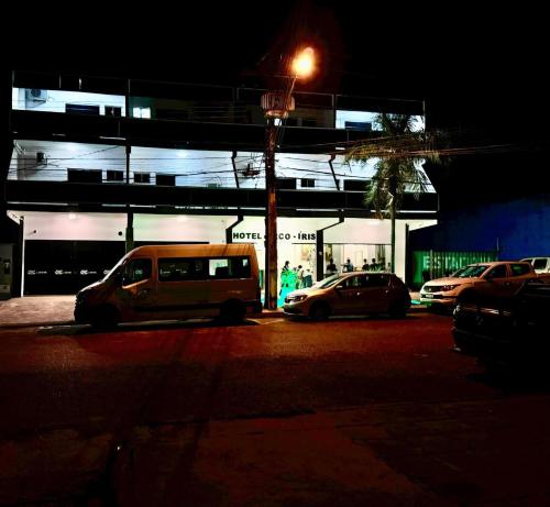 um grupo de carros estacionados num parque de estacionamento à noite em Hotel Arco Iris Palmas em Palmas