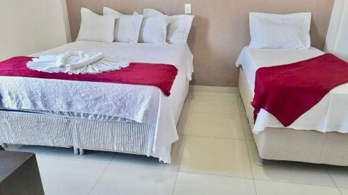 um quarto com duas camas com toalhas na cama em Hotel Arco Iris Palmas em Palmas