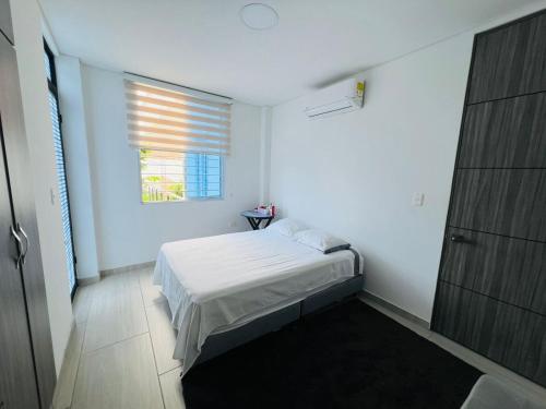 a small bedroom with a bed and a window at Apartamento King in Yopal