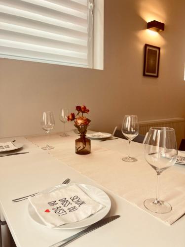 a table with wine glasses and a plate on it at M&N Apartments in Bad Bevensen