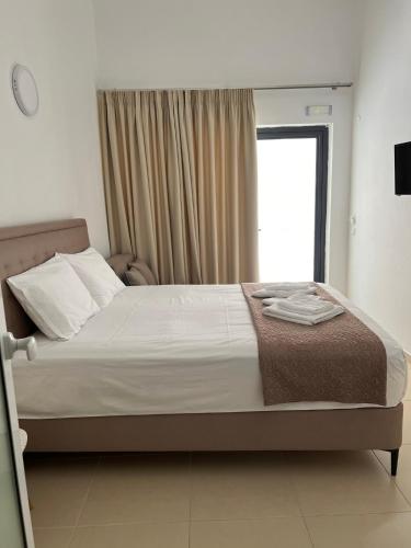 a large bed in a bedroom with a window at Sun's Suites in Asprovalta