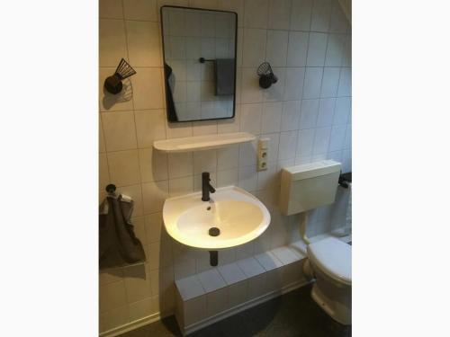 a bathroom with a sink and a toilet at Holiday apartment Strackholt in Großefehn 