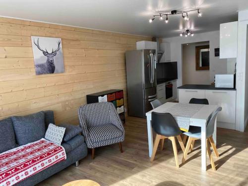 un salon avec un canapé et une table et une cuisine dans l'établissement T3 plein centre ville Font Romeu parking couvert, à Font-Romeu-Odeillo-Via