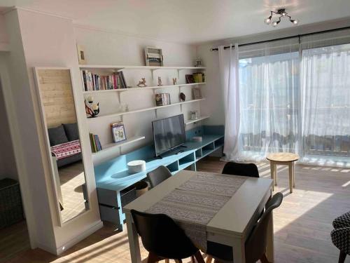 un salon avec une table et un bureau avec une télévision dans l'établissement T3 plein centre ville Font Romeu parking couvert, à Font-Romeu-Odeillo-Via