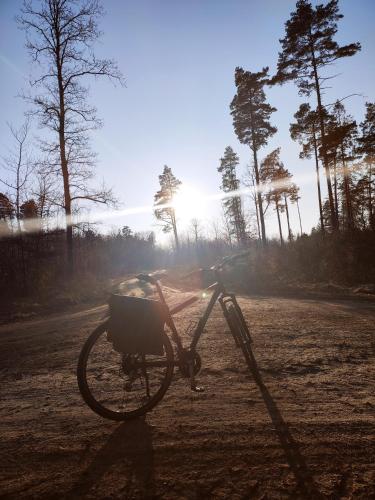 a bike parked in a field with the sun in the background at Apartament Loft na Kaszubach - Laskowa Góra Bieszkowice in Bieszkowice