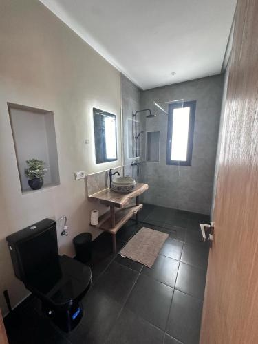 a bathroom with a sink and a chair and a mirror at Villa Karama Essaouira Getaway in Bou Mkila