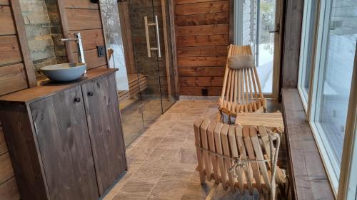 a bathroom with a sink and a wooden chair at Fjellyx i funäs med relax&bastu, badtunna, 13 bädd in Funäsdalen